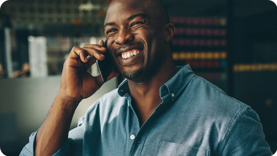 Smiling businessman talking on mobile phone in office.